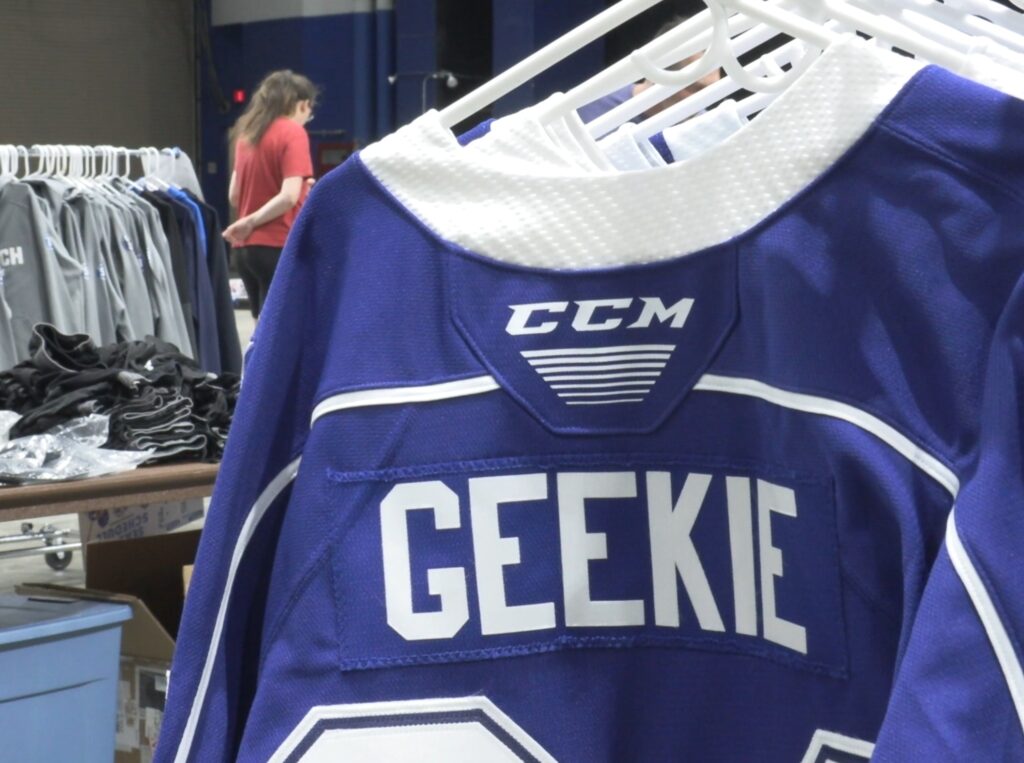 A hockey jersey on a hanger. 